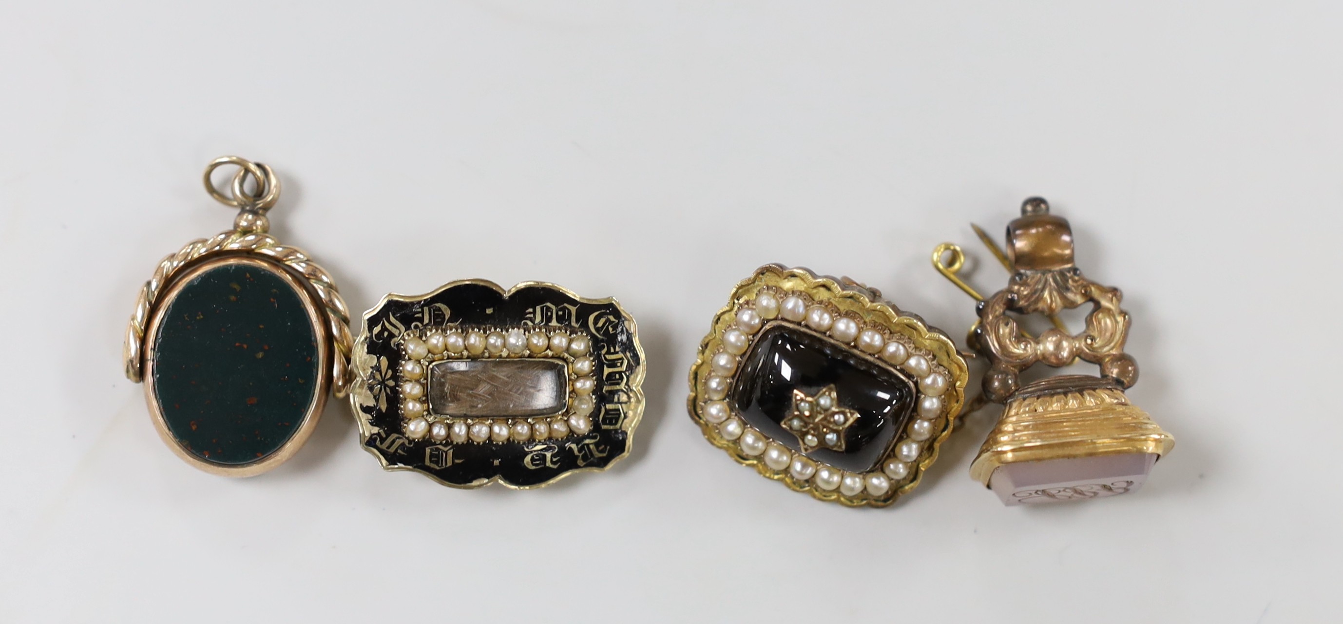 Two Victorian yellow metal and split pearl set mourning brooches, one with black enamel and inscribed ' JG aged 69 August 29th, 1840' and two Victorian yellow metal overlaid and chalcedony set fob seals.